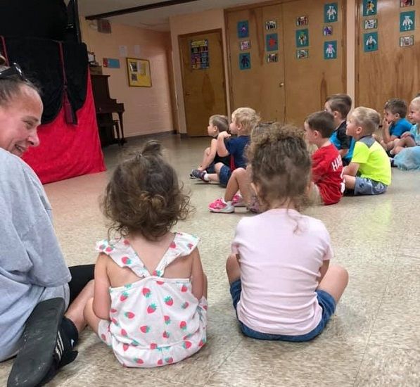 Children sitting on the floor for circle time with their teacher