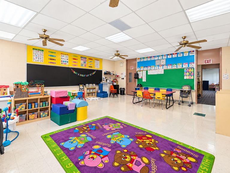 Bright, colorful St. Luke's Day School classroom with an alphabet wall, reading corner and small tables