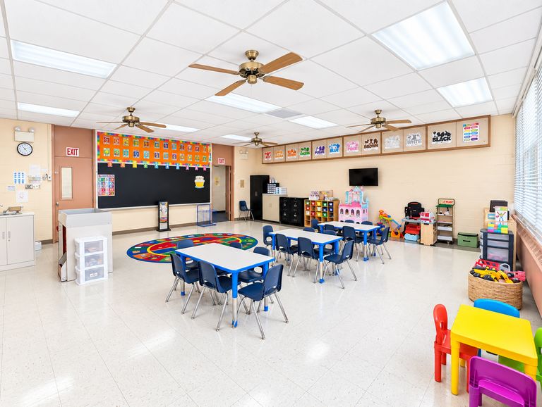 St. Luke's classroom with round tables, blue chairs and a colorful rug